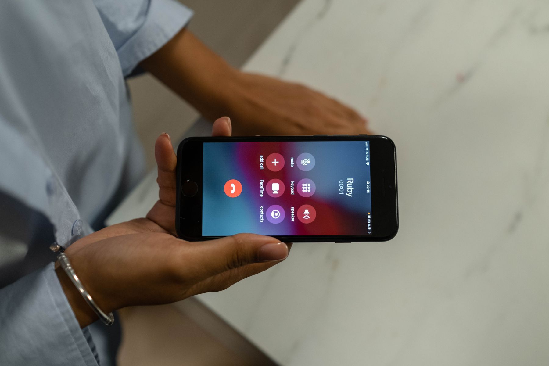 Hand hält ein Smartphone mit eingehendem Anruf